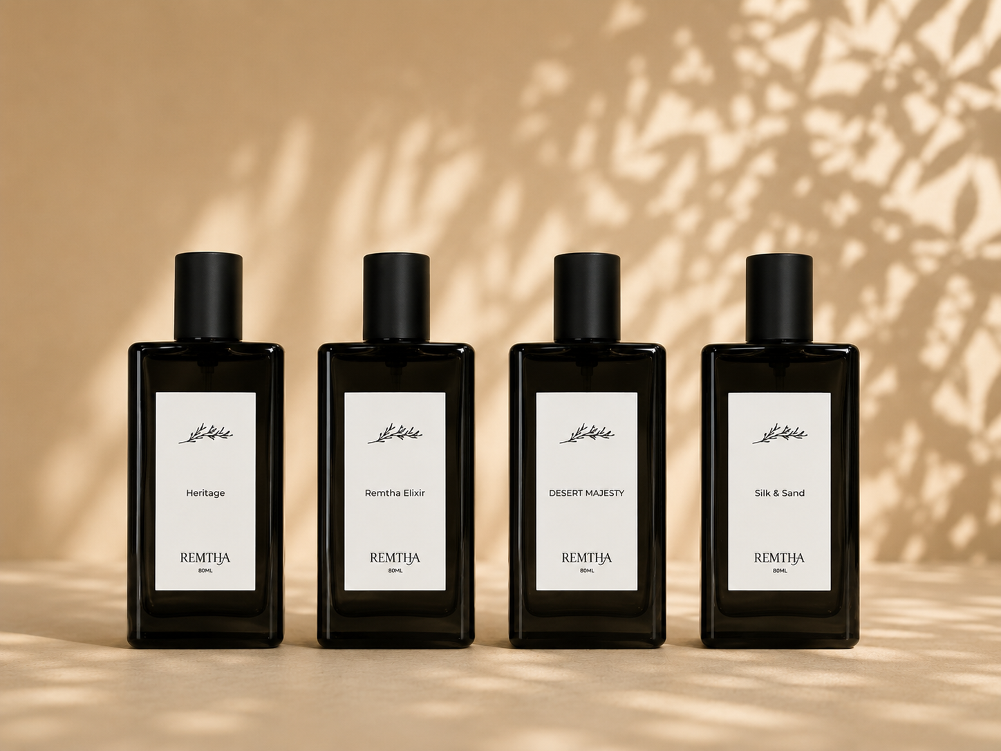 The four REMTHA perfume bottles lined up against warm desert light